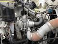 A close-up view of the engine components of a 2016 Peterbilt 348 showcasing the turbocharger and various connected pipes and hoses