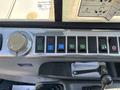 The control panel of a 2010 Bobcat E80 featuring various colored buttons for different functions and a large rotary dial