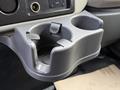 A gray cup holder from a 2012 International 4300 truck with two compartments and a circular insert for fitting cups or bottles