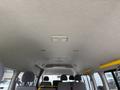Interior view of a 2009 Toyota Hiace showing the ceiling with lights and air vents along with rows of seats visible in the foreground