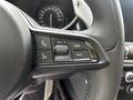 Close-up of the steering wheel controls of a 2023 Alfa Romeo Giulia featuring buttons for volume call and media navigation