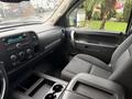 Interior view of a 2013 Chevrolet Silverado 3500HD showcasing the dashboard and passenger seat with black fabric upholstery and center console with cup holders