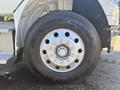 A close-up of a wheel on a 2022 Freightliner M2 106 featuring a shiny metal rim with multiple bolts and a large black tire with the size markings 11R22.5