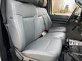 A 2015 Ford F-350 interior featuring two front leather seats in light gray with a simple and clean design