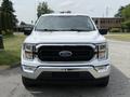 A white 2021 Ford F-150 with a prominent black grille and modern design features is centered in the image