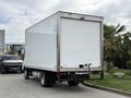 A 2018 Hino 195 truck with a large white cargo box and visible rear lights parked on a street