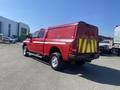 A red 2015 RAM 2500 pickup truck with a matching cap on the bed and reflective yellow stripes on the back