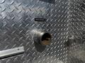 A metal plate labeled Rear Discharge with a circular opening for discharge mounted on a diamond-patterned metallic surface