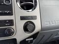 Close-up of dashboard controls in a 2015 Ford F-550 featuring audio controls climate settings and a 12V power outlet