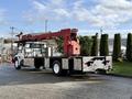 A 2010 International 4300 truck with a flatbed and a red crane mounted on the back positioned at a slight angle