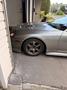 A 1997 Toyota Supra with a streamlined design and prominent hood scoops parked partially inside a garage with a sporty stance and alloy wheels