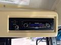 A Panasonic CD player and radio unit with a digital display and controls mounted inside the overhead compartment of a vehicle
