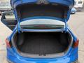 A blue 2021 Kia Forte with an open trunk showing the spacious interior devoid of any items