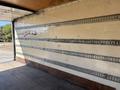 2022 Isuzu NRR empty cargo area with wooden floor and metal track system along the walls for securing cargo