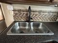 Double stainless steel sink with two basins and a black faucet in a camper kitchen