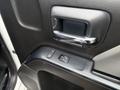 The interior door panel of a 2016 GMC Sierra 1500 featuring a chrome door handle and window control buttons