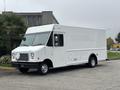 A white 2012 Ford E-450 Super Duty box truck with a flat front and large cargo area parked on a street