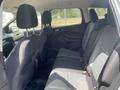 Interior of a 2015 Ford Escape showing the backseat area with two headrests and three seat cushions in black fabric upholstery