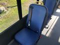 A blue passenger seat with a seatbelt in a bus interior