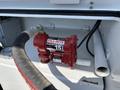 A red Fill-Rite 15-gallon per minute DC pump mounted on a surface with hoses attached