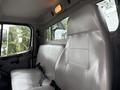 Interior view of a 2021 Freightliner M2 106 featuring a gray leather seat with a seatbelt and a simple dashboard design