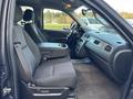 Interior view of a 2011 Chevrolet Avalanche showing front seats and center console with dark fabric upholstery