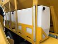 A white tank mounted on a yellow frame of a 2016 International 7400 vehicle