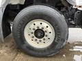 Close-up of a 2014 International 7500 truck tire showcasing the tread pattern and metallic rim with lug nuts visible