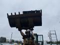 A 2016 Hyundai HL940 loader with a large bucket raised high above its frame showcasing its digging capabilities
