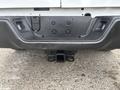 A rear view of a 2016 RAM 1500 truck's bumper featuring a towing hitch receiver and mounting points for accessories