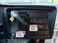 The dashboard controls of a 2014 International 4300 featuring switches levers and warning labels