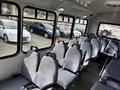Interior view of a 2018 Chevrolet Express with rows of blue fabric seats and seat belts visible