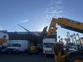 A 2013 JCB 510-56 Loadall with an extended arm and attachment in a industrial setting