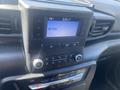 Dashboard of a 2020 Ford Explorer showing a digital display with radio information and control buttons for audio and climate settings