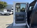 A 2012 Ford F-350 SD with an open door displaying the interior handle and storage compartment