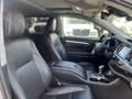 Interior of a 2018 Toyota Highlander featuring black leather seats and a central dashboard with a touchscreen display and gearshift console