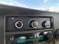 Dashboard controls of a 2017 Chevrolet Express featuring climate control knobs and a radio display showing frequency and station information