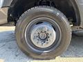 A close-up view of a wheel and tire from a 2017 Ford F-550 featuring a silver metal rim and a rugged black tire with tread patterns designed for durability