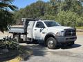 A 2016 RAM 5500 pickup truck with a flatbed and toolboxes on the side parked on a driveway