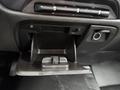 The image shows the open glove compartment of a 2015 GMC Sierra 1500 featuring a sleek black interior with storage space and a small clip for holding items