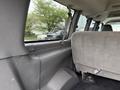 Interior view of a 2004 Chevrolet Express showing the back seat area with gray upholstery and seatbelts
