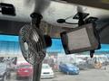 A black oscillating fan mounted to the ceiling next to a digital display screen affixed to the interior of a 2018 Ford Econoline