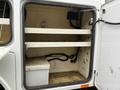 A 2015 Ford F-450 service truck with an open compartment showcasing two shelves and a white storage box on the floor