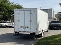 A 2019 Ford Econoline cargo van with a white box body and rear double doors parked at an angle