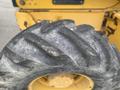 Close-up of a treaded tire from a 2012 John Deere 310SJ showcasing deep grooves for traction and a robust rubber surface