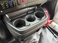 A cup holder console with three circular openings for drinks inside a 2020 Chevrolet Express vehicle