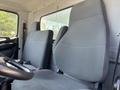 Interior view of a 2020 Hino 338 showing two fabric-covered seats designed for driver and passenger with a steering wheel visible in the foreground