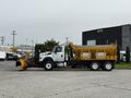 2016 International 7600 truck with a front-mounted snow plow and a large yellow salt spreader attached to the back