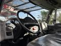 The interior of a 2010 International 4300 featuring a steering wheel dashboard controls and a driver seat with leather upholstery