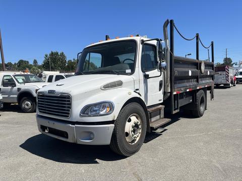 A 2007 Freightliner M2 106 truck with a flatbed design featuring a black cargo area and visible tires and wheels